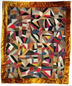 Quilt with seams between the pieces are decorated with a large variety of multicolored stitches