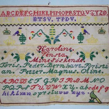 Alphabet sampler (navneduk) was done in bright colored cross-stitches on a fairly coarse canvas backing - Textiles