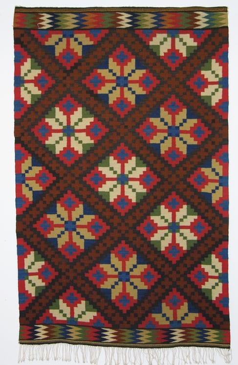 Coverlet with large eight-petal flowers that are divided by diagonal bands of crosses - Textiles