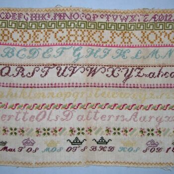 alphabet sampler done on a natural colored canvas-backing in cross-stitch using two strands of wool yarn - Textiles