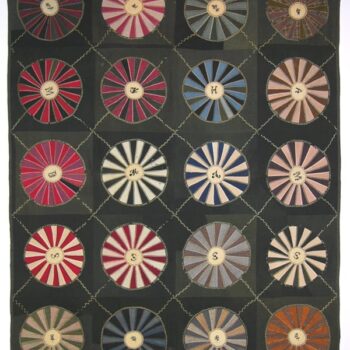This pieced quilt was made predominantly from wool fabrics in a pattern known as Wagon Wheel or Wheel of Chance - Textiles