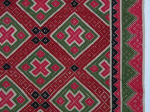 Coverlet with pattern in two-ply wool of diamonds and related geometric forms in two shades of red, green, and dark blue - Textiles