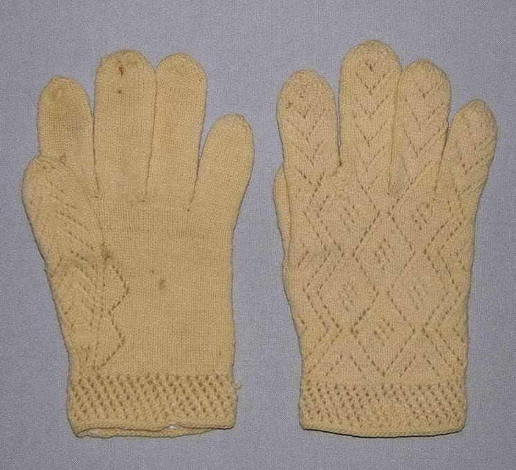 Gloves with knit lace patterns on the backs, along thumbs, and around the wrists - Textiles