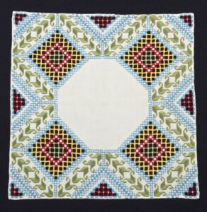 Doily with Hardanger embroidery in green, red, yellow, and blue - Textiles