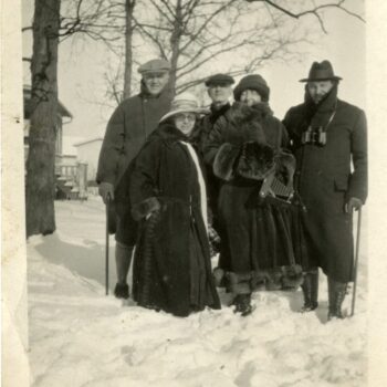 Five people pose outside in the snow for a photograph.