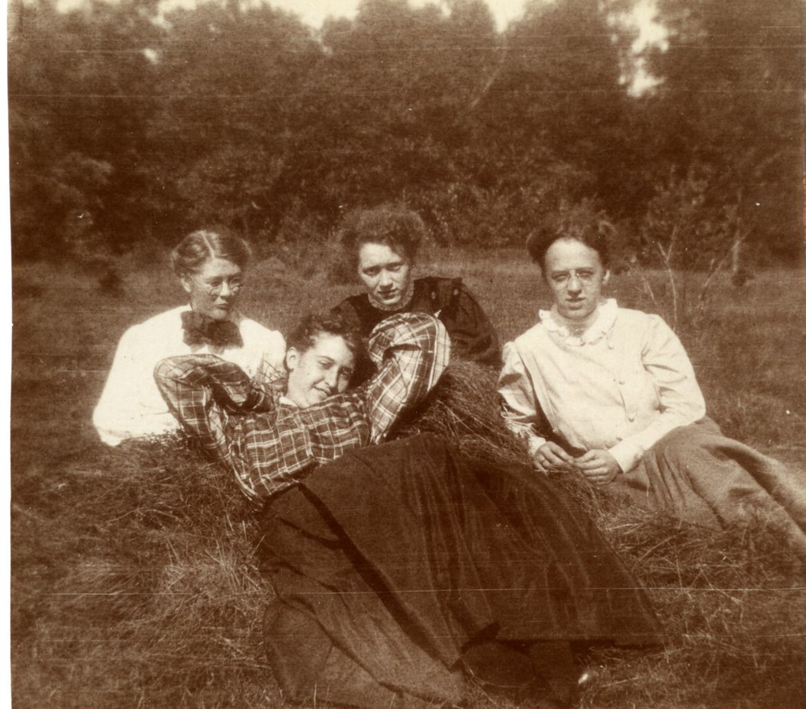 Four women pose for a photograph in a field.