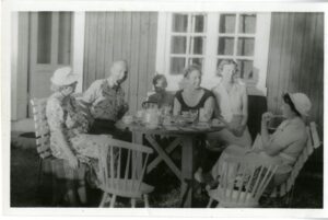 Group of six have a meal outside.