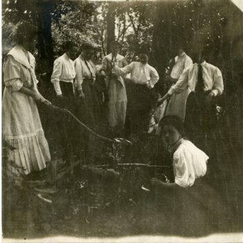 Group of about eight women cook over a fire.