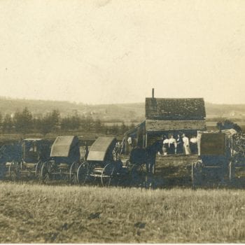 Group of women at farm with many horse and buggies.