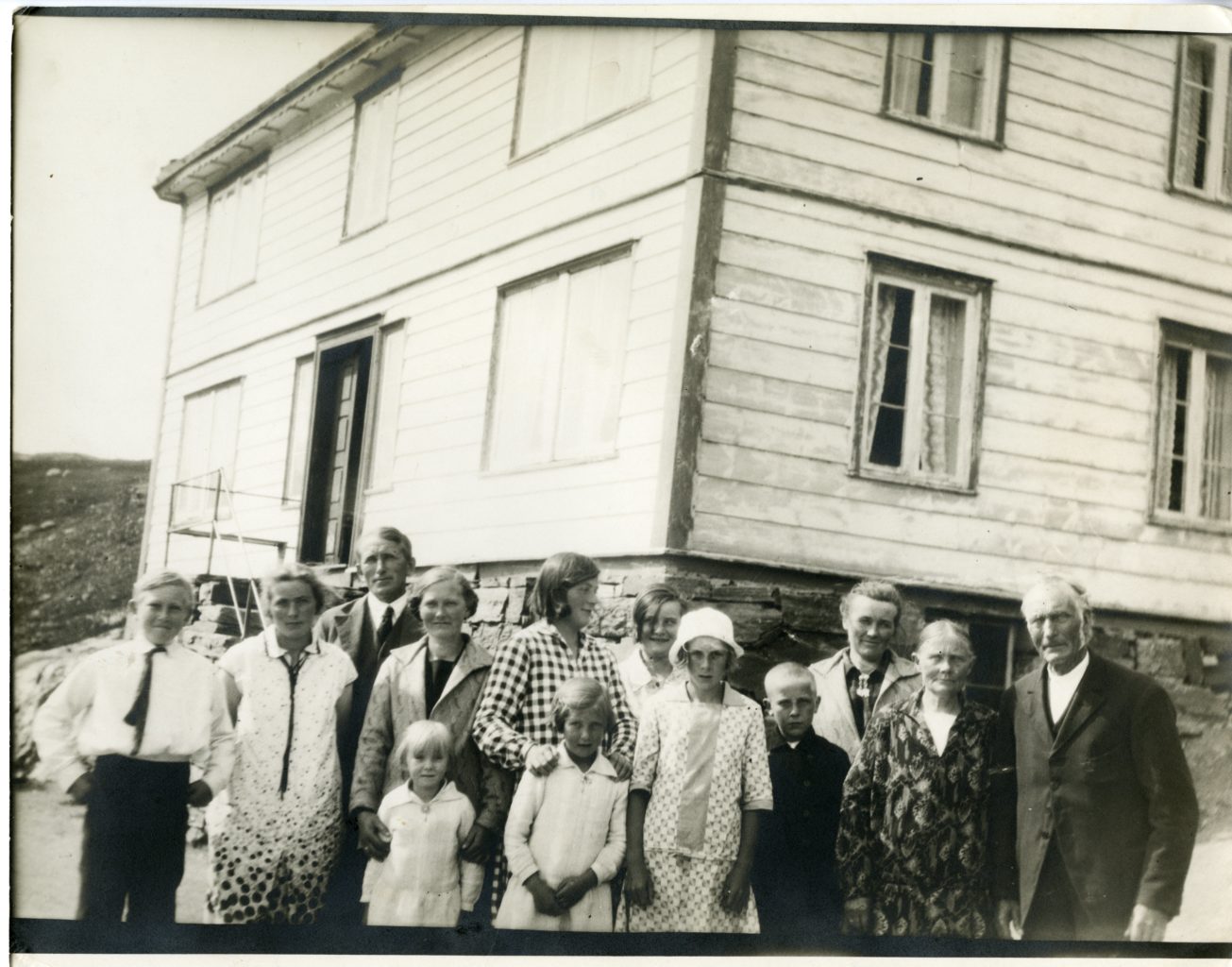 Large group of family nicely dressed outside of home in Roldal, Norway.