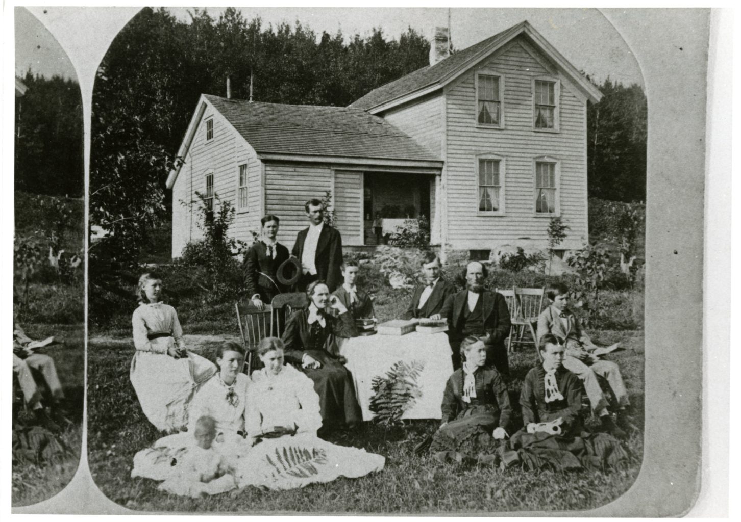 A family sits outside with books.