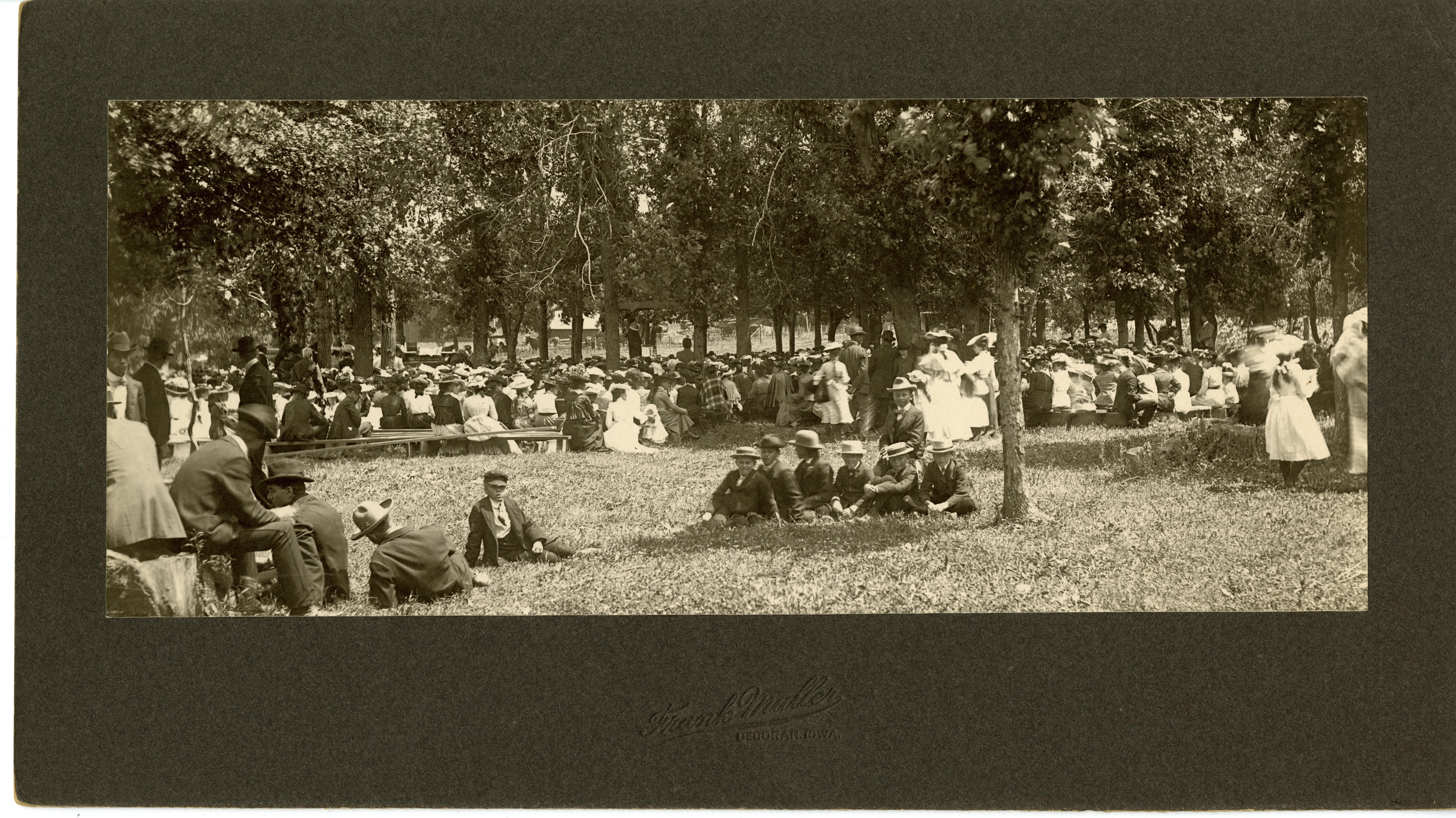 Large gathering of men, women, and children outside, possibly for church service.