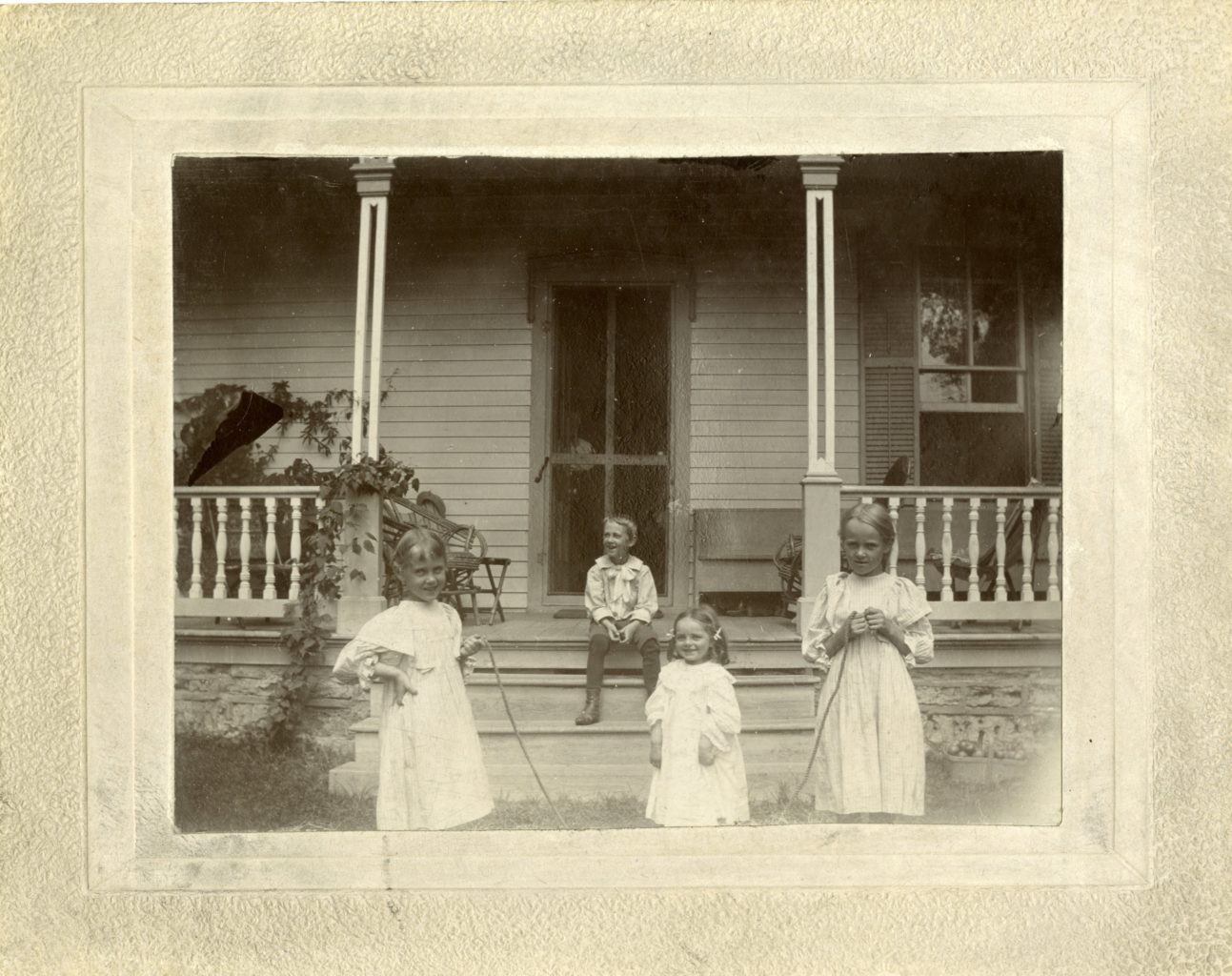 Elsa Marie, Esther, two more children play jump rope outside of Koren House at Washington Prairie Parsonage.
