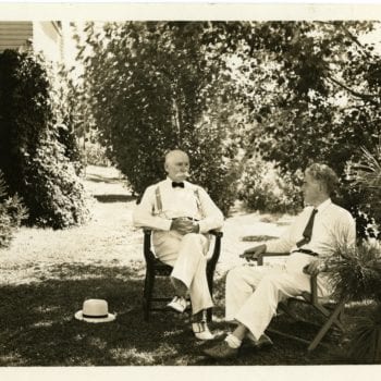 Two men sit outside together.