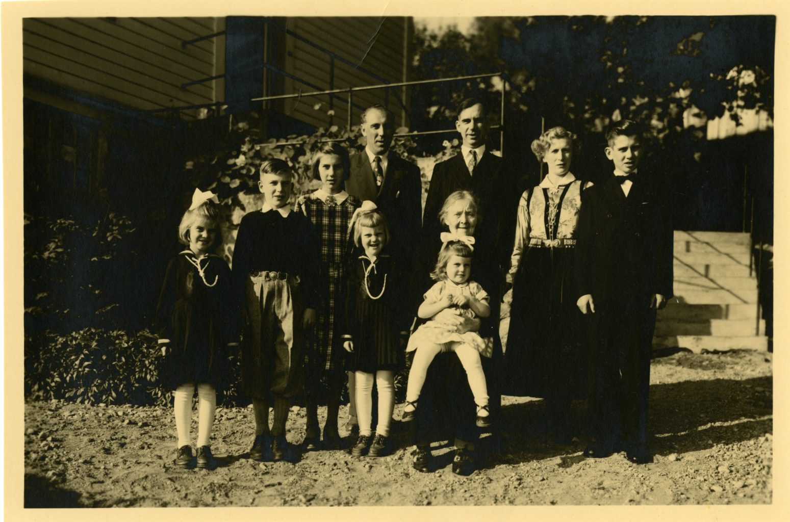 Group photo of family, one female wears Norwegian national dress.