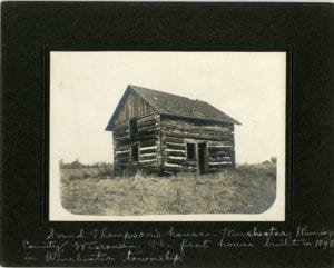 Log home in the middle of a field.