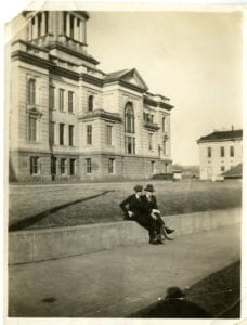 Two men sit outside of the Decorah Courthouse.