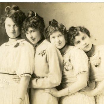 Four girls pose together in the studio.