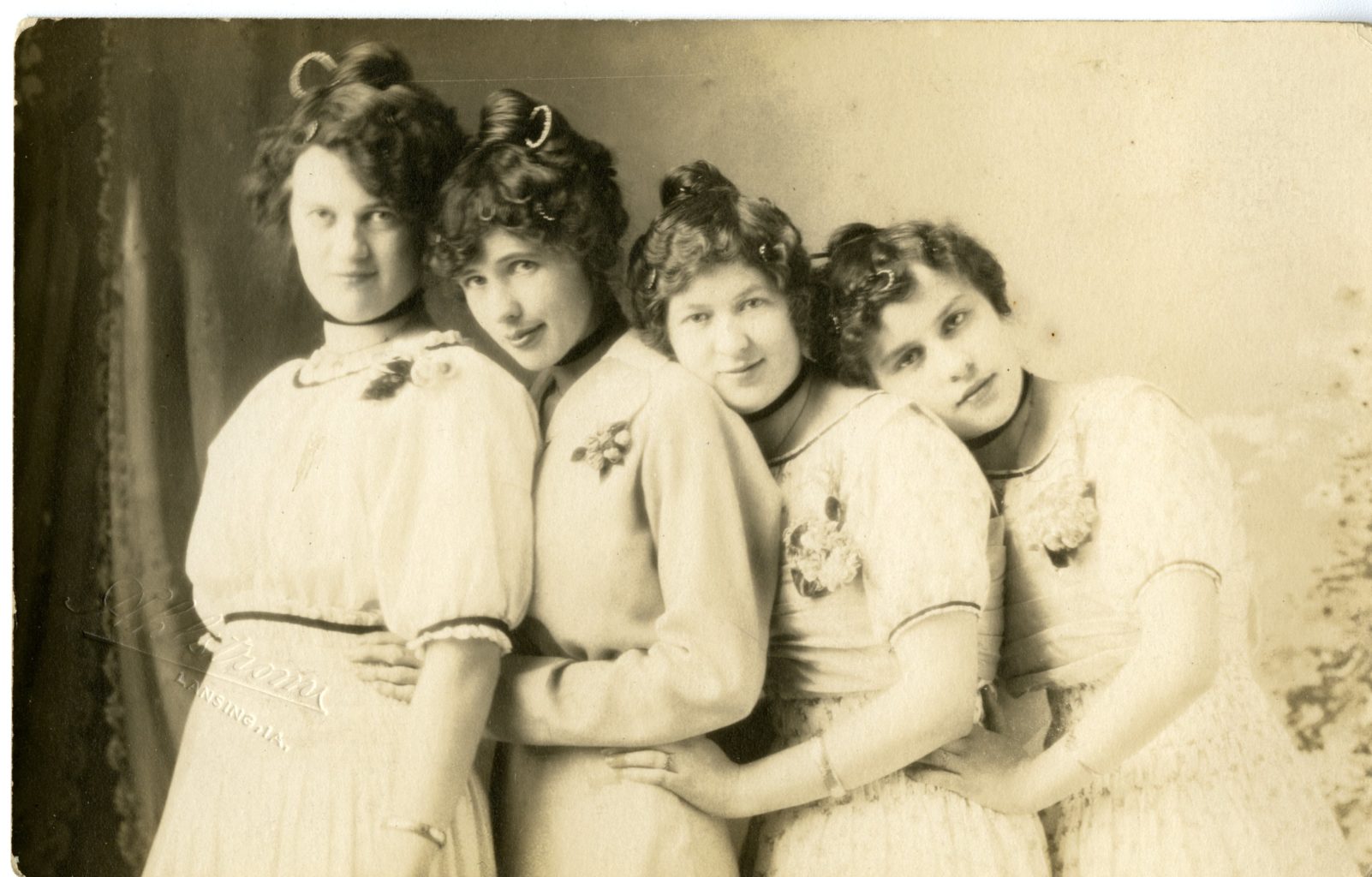 Four girls pose together in the studio.