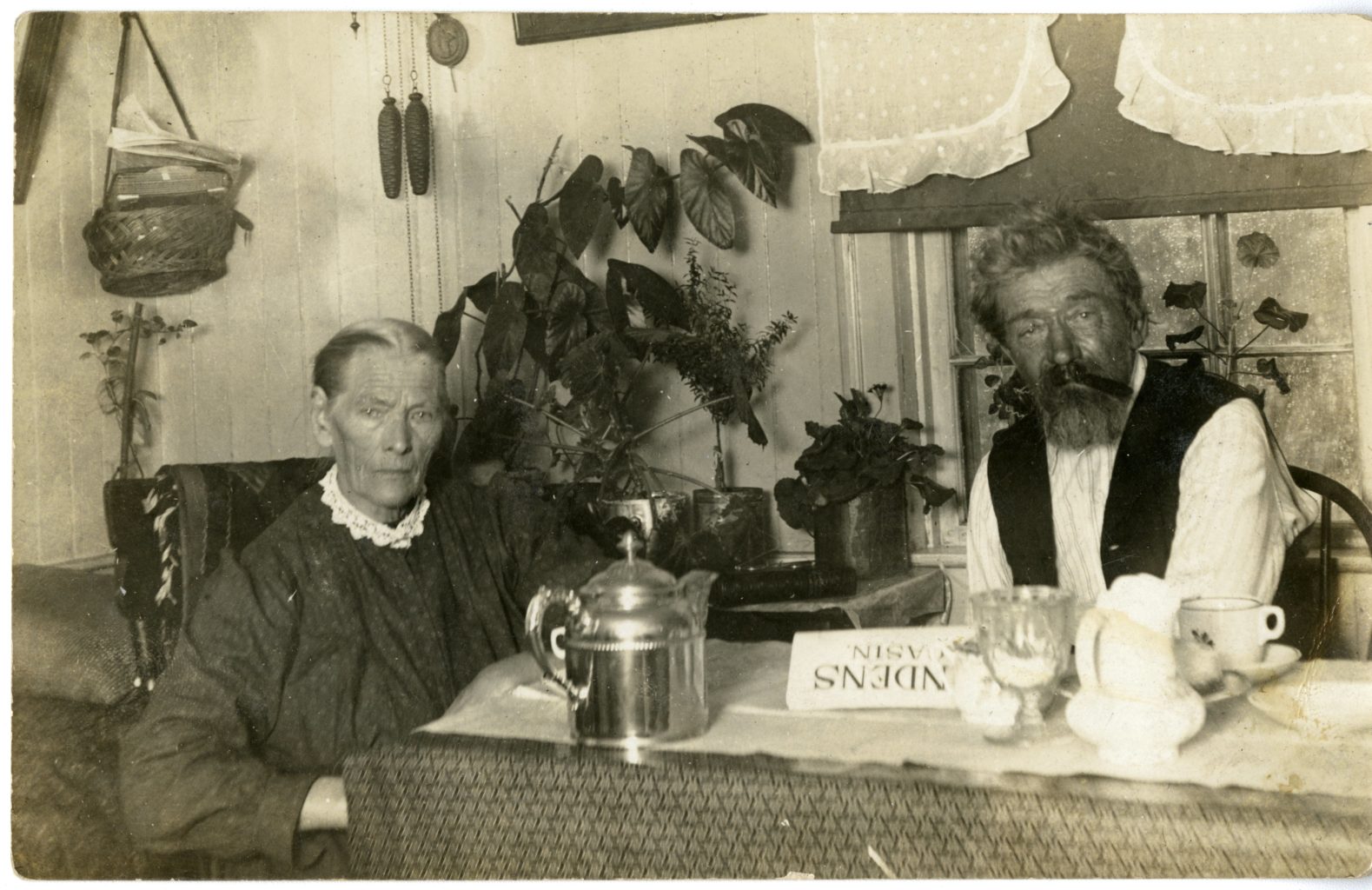 Man and woman sit together inside around a table.