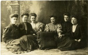 Six women pose in studio.